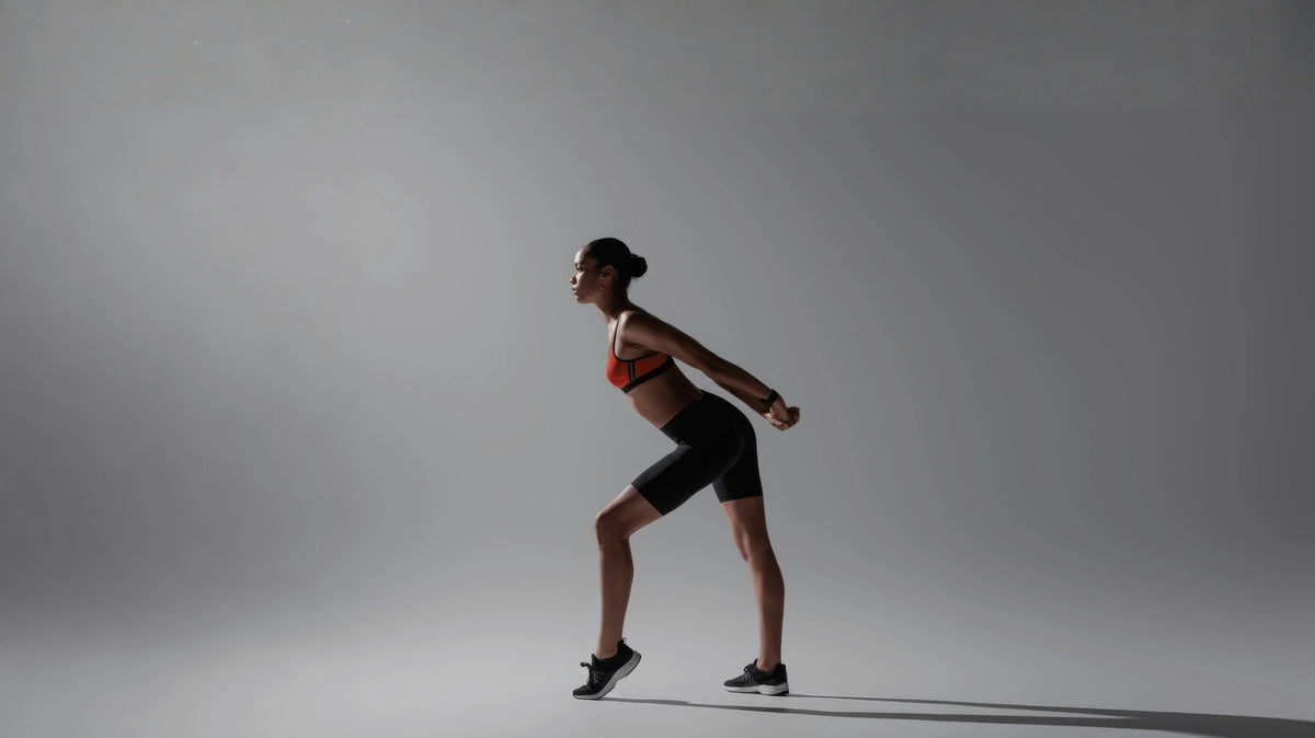 woman in athletic wear standing against a gray background